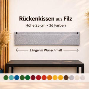 Può includere: Un cuscino schienale in feltro grigio chiaro, alto 25 cm, con un dettaglio a tasca, montato su una parete. L'immagine include il testo in tedesco: "Rückenkissen aus Filz, Höhe 25 cm, 36 Farben, Länge im Wunschmaß." Un tavolo nero e una tavolozza di colori sono sotto.