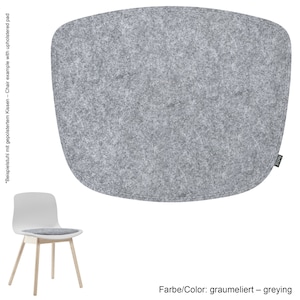 Könnte beinhalten: Ein hellgraues, oval geformtes Stuhlkissen aus Filz. Das Kissen hat eine genähte Bordüre und ein kleines Etikett in der unteren rechten Ecke. Der Text "Farbe/Color: graumeliert - greying" befindet sich am unteren Bildrand.