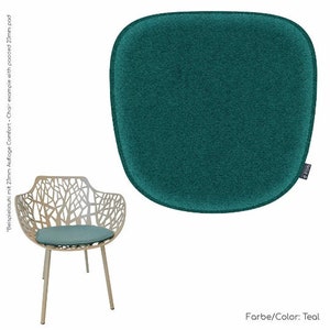 Könnte beinhalten: Tealfarbener Stuhlkissen mit abgerundeter Form und strukturiertem Stoff. Das Kissen ist 23 mm dick und hat ein "Killa" Logo unten rechts.  "Farbe/Color: Teal" steht unter dem Kissen.