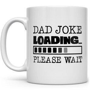 May include: White ceramic coffee mug with black text that reads "Dad Joke Loading... Please Wait". The text is in a loading bar format with a progress bar that is almost full.