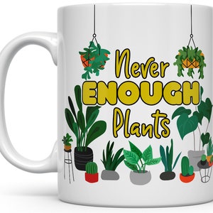 Puede incluir: Taza de cer&aacute;mica blanca con un dise&ntilde;o de plantas verdes, amarillas y naranjas y el texto "Never Enough Plants".
