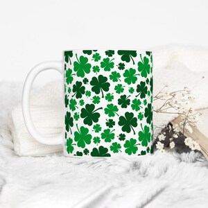 May include: White ceramic mug with a green shamrock pattern.