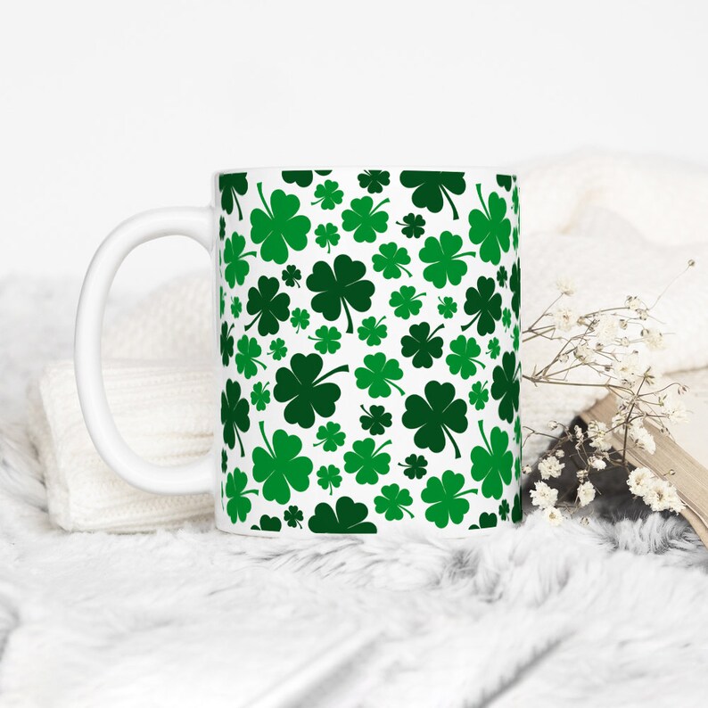 May include: White ceramic mug with a green shamrock pattern.