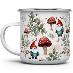 May include: White enamel mug with a whimsical design featuring gnomes wearing red hats and blue outfits, mushrooms with red tops and white spots, and green foliage.