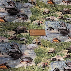 Puede incluir: Una tela colorida con un patrón repetitivo de tortugas sobre un fondo azul y verde. Las tortugas están en varias poses, algunas nadan, otras están en rocas y otras están en el suelo. La tela es perfecta para acolchar, manualidades y otros proyectos.