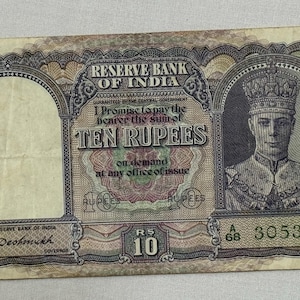 Puede incluir: Un billete antiguo de diez rupias del Banco de la Reserva de la India. El billete presenta un retrato de un hombre con corona y el texto "TEN RUPEES". El billete tiene un número de serie y el texto "RESERVE BANK OF INDIA".