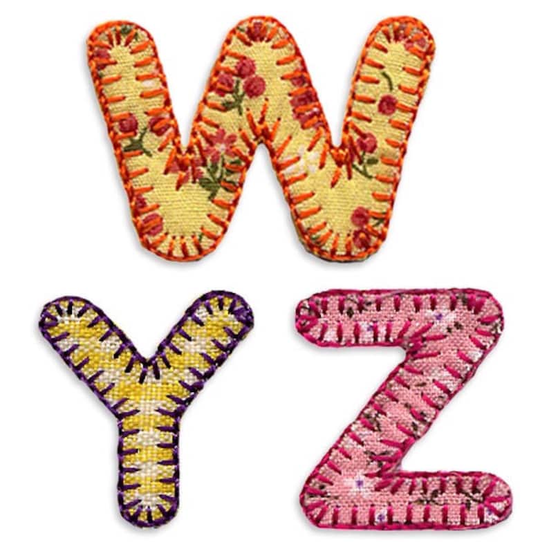 May include: Three fabric letters, W, Y, and Z, are stitched together with colorful thread. The W is yellow with orange thread and a floral pattern. The Y is yellow with purple thread. The Z is pink with red thread.