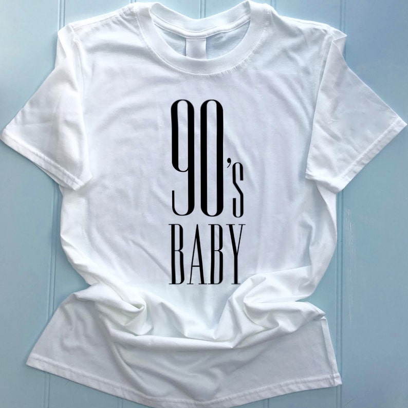 May include: White t-shirt with black text that reads "90's BABY"