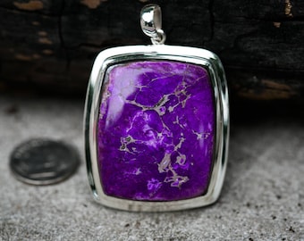 May include: A silver pendant with a purple and white gemstone. The gemstone has a marbled pattern.