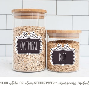May include: Two glass jars with bamboo lids, filled with oatmeal and rice.  The jars have black and white labels with the words "Oatmeal" and "Rice" printed on them.