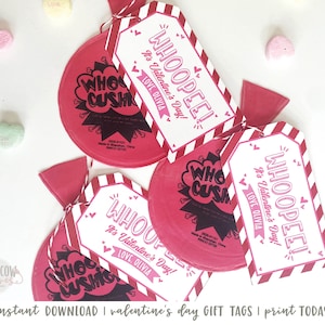 May include: Red and white Valentine's Day gift tags with the text "WHOOPEE! It's Valentine's Day!" and "LOVE OLIVIA". The tags are attached to red and white striped candy bags with the text "WHO CUSH".