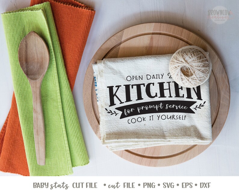K&ouml;nnte beinhalten: Ein wei&szlig;es K&uuml;chentuch mit schwarzem Text, der "Open Daily 2 Kitchen for prompt service. Cook it yourself." lautet. Das Tuch wird auf einem Holzbrett mit einer Schnurkugel pr&auml;sentiert.