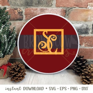 May include: A round, red and white, decorative sign with a gold monogram of the letter "S" in a square frame. The sign is on a brick background.