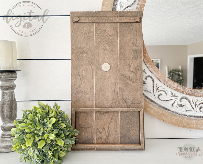May include: A wooden wall shelf with a single shelf and a small, round, white knob. The shelf is stained a dark brown color and has a rustic look.