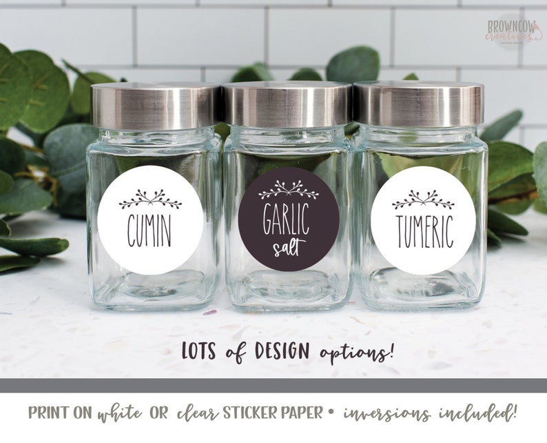 May include: Three glass spice jars with silver lids and round white labels with black text and simple floral designs. The labels read "Cumin", "Garlic Salt", and "Tumeric".