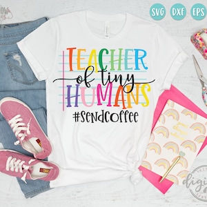 May include: A white t-shirt with the text "Teacher of tiny humans #sendcoffee" in rainbow colors. The text is on a blue and white striped background.
