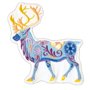 Puede incluir: Un reno azul bordado con cuernos amarillos y diseños florales intrincados. El reno está de pie sobre un fondo blanco.