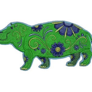 May include: Green embroidered patch of a hippopotamus with blue and yellow floral designs.