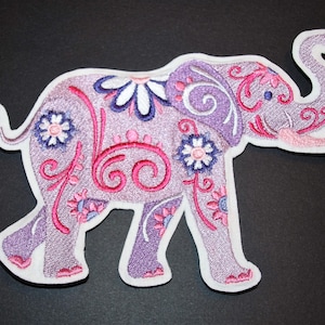 May include: Purple and pink embroidered elephant patch with floral designs. The elephant is walking and has its trunk raised.