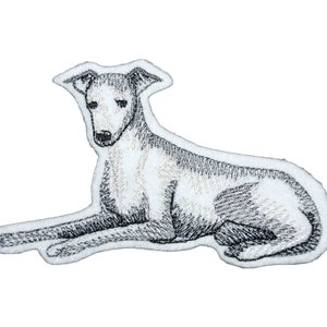 Puede incluir: Parche bordado en blanco y negro de un perro acostado. El perro es de raza galgo, con un cuerpo largo y delgado y un hocico puntiagudo.