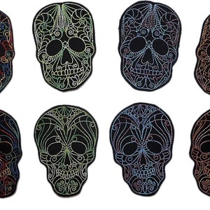 Puede incluir: Ocho parches bordados de calavera con diseños intrincados en varios colores, incluyendo rojo, azul, verde y dorado. Las calaveras están delineadas en negro y tienen un fondo negro.