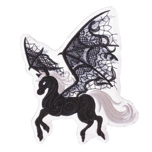 Peut inclure: Patch brodé noir et blanc d'une licorne ailée avec des ailes en dentelle. La licorne est debout sur ses quatre pattes, la tête tournée sur le côté. Les ailes sont déployées derrière la licorne.