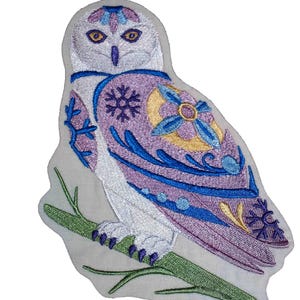 Puede incluir: Parche bordado de búho en blanco, lavanda, azul y amarillo. El búho está posado en una rama verde. El diseño del búho incluye patrones florales y de copos de nieve. Adecuado para chaquetas, bolsos u otros artículos de tela.