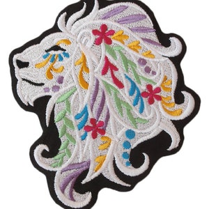 Könnte beinhalten: Weißer gestickter Löwenkopf-Patch mit bunten floralen Details. Die Löwenmähne ist aufwendig mit Schnörkeln und Blumen in den Farben Rosa, Gelb, Blau und Grün gestaltet.