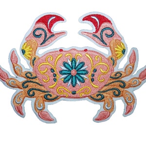 May include: Embroidered iron-on patch of a pink crab with yellow, green, and blue floral details.