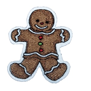 以下が含まれることがあります： 白いアイシングと赤と緑のキャンディーのディテールが付いた、ジンジャーブレッドマンの刺繍パッチです。