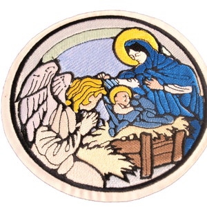 Puede incluir: Parche bordado que representa la escena de la Natividad con un ángel con halo, María y el niño Jesús en un pesebre. El ángel tiene alas y está arrodillado en oración. María lleva una túnica azul y sostiene al niño Jesús. El pesebre está hecho de madera y paja.