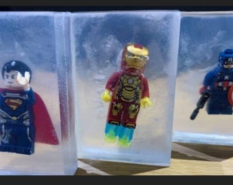 Può includere: Tre blocchi di plastica trasparente, ognuno contenente una diversa minifigure Lego di un supereroe. Le minifigure sono Superman, Iron Man e Captain America.
