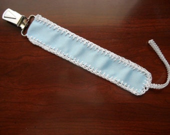 Blue and white pacifier clip made of blue ribbon and hand cochet white trim. Fits most pacifier types.