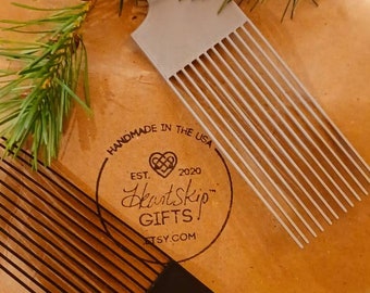 May include: Two combs, one black and one gray, with a brown paper background. The paper has a logo that says "HeartSkip Gifts" with a heart and the text "Handmade in the USA, Est. 2020, Etsy.com".