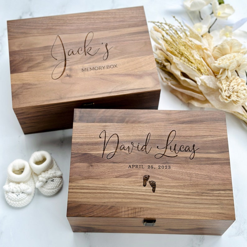 May include: Two wooden memory boxes with engraved names and dates. The top box says "Jack's Memory Box". The bottom box says "David Lucas April 25, 2023" with a footprint design.