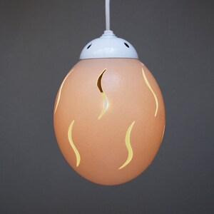 Slit themed ostrich egg pendant: Carefully carved to allow the warm glow of the light to spill out, the overall effect is simple and elegant