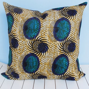 May include: A decorative cushion with a geometric pattern of blue, green, black and gold swirls on a cream background.