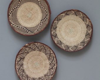 Kies uit 2 sets Tonga manden 34-36cm: Contrasterende bruine en crème ranken en palmbladeren zijn met elkaar verweven om patronen te creëren