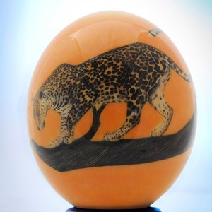 Decoupage leopard ostrich egg: A single leopard stalks his prey along a tree branch on the front of this ostrich eggshell decor item