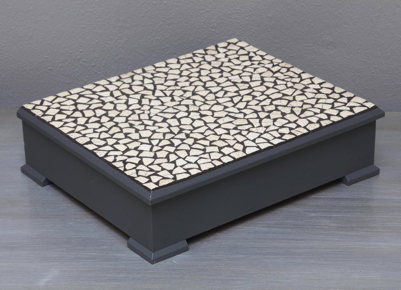 African gift box: this display storage box comes in two sizes, is rendered in grey hues and is encrusted with mosaic pieces of ostrich egg 27.5x18x23 cm