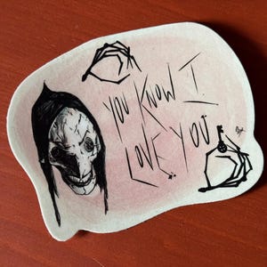May include: A sticker with a black and white illustration of a creature with a long, pointed nose and large eyes. The creature is wearing a black hood. The sticker also features the text "You know I love you" in black ink on a pink background.