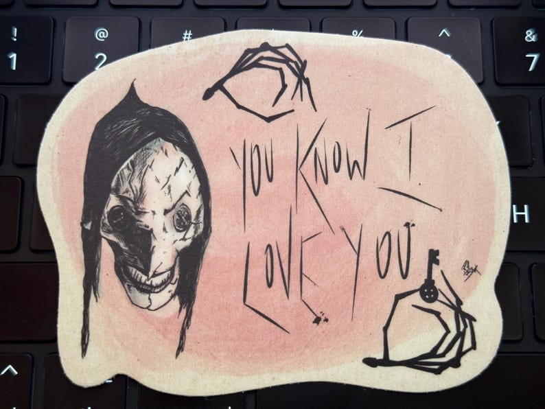 May include: A pink and white sticker with a black and white illustration of a creepy character with a stitched face and the text "You know I love you".
