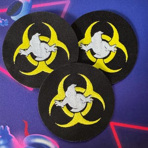 May include: Three black and yellow biohazard symbol patches with a white cartoon penguin inside each symbol.