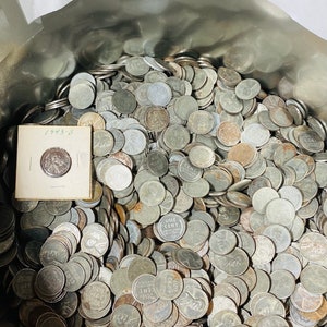 May include: A metal container filled with a large collection of silver US pennies. The pennies are dated 1943-S and other years. The container is labeled "ProofsandPennies".