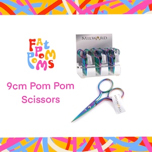 Pode incluir: Um expositor de tesouras para pompons de 9 cm de arco-íris da marca "Milward". As tesouras são exibidas em um suporte branco com um logotipo de arco-íris que diz "Fat Pom Poms".