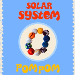 Peut inclure: Un fond bleu avec les mots "SOLAR SYSTEM" en orange et "POMPOM" en jaune. Un cercle de pompons colorés représente les planètes. Les pompons sont de différentes couleurs, dont l'orange, le bleu et le blanc.