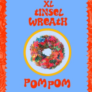 May include: XL Tinsel Wreath Pom Pom, a large, colorful wreath made of tinsel and pom poms. The wreath is displayed on a white plate with a yellow border.