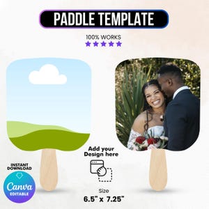 May include: Paddle template with a wooden handle. One side features a landscape design with a blue sky and green hills. The other side displays a photo of a smiling couple. The size is 16.51 cm x 18.42 cm.