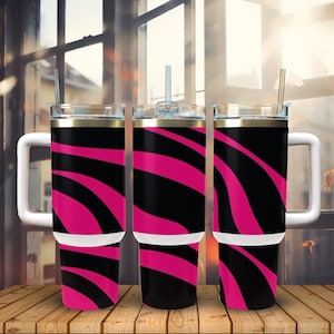 K&ouml;nnte beinhalten: Drei Edelstahlbecher mit schwarz-rosa Zebra-Muster. Jeder Becher hat einen wei&szlig;en Deckel, einen goldenen Rand und einen wei&szlig;en Griff.
