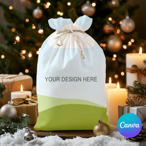 May include: A white Christmas gift bag with a green and white landscape design. The bag has a drawstring closure and the text "YOUR DESIGN HERE" is printed on the front.